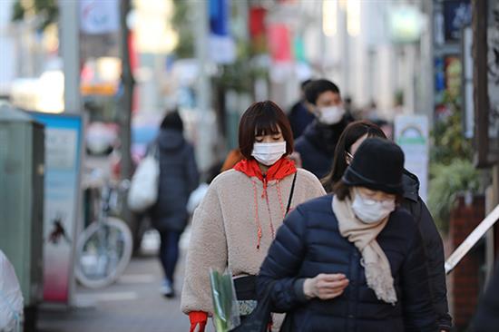 12月31日，在日本东京，行人戴口罩出行。新华社 图
